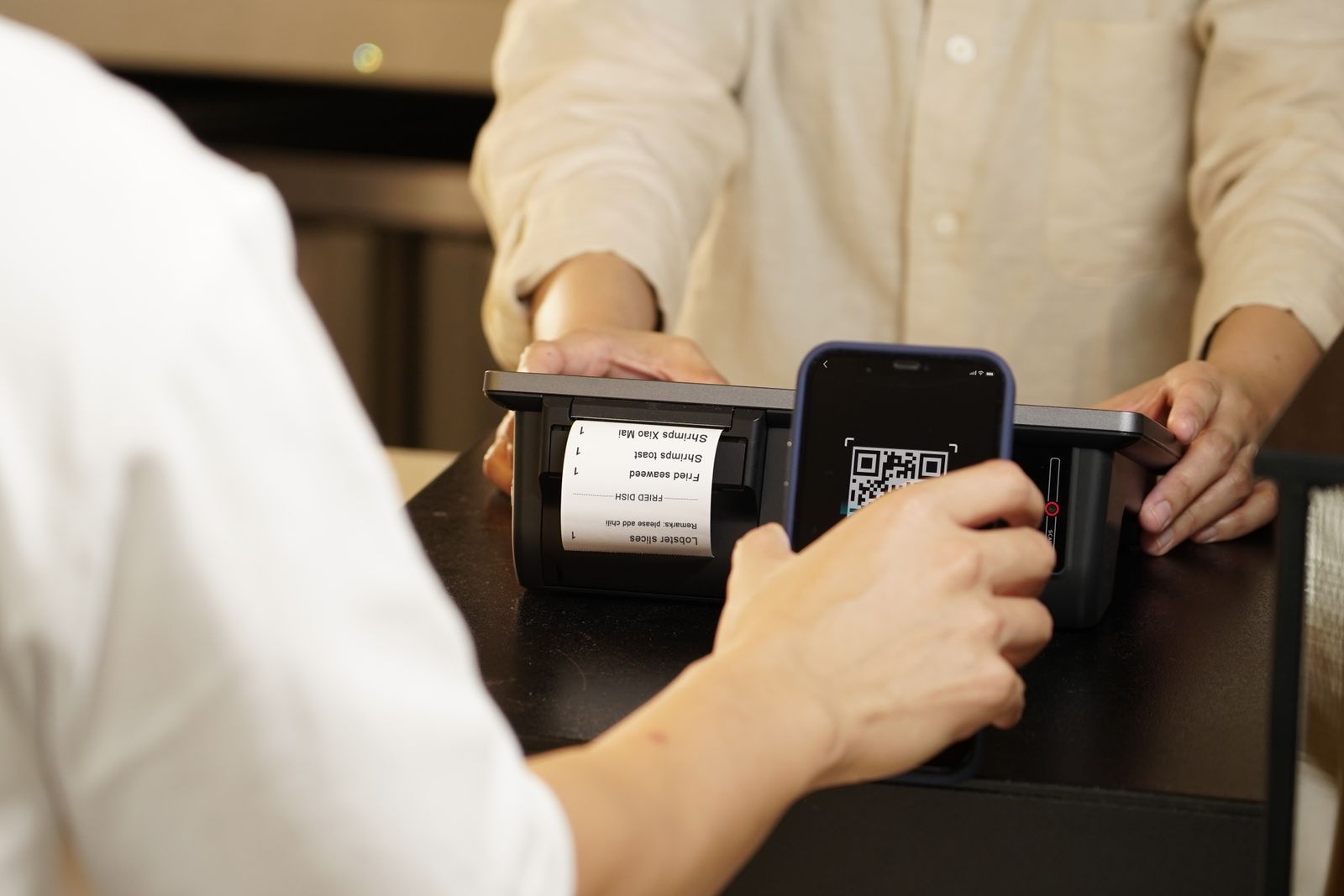 Customer scanning a QR code to pay at a retail counter