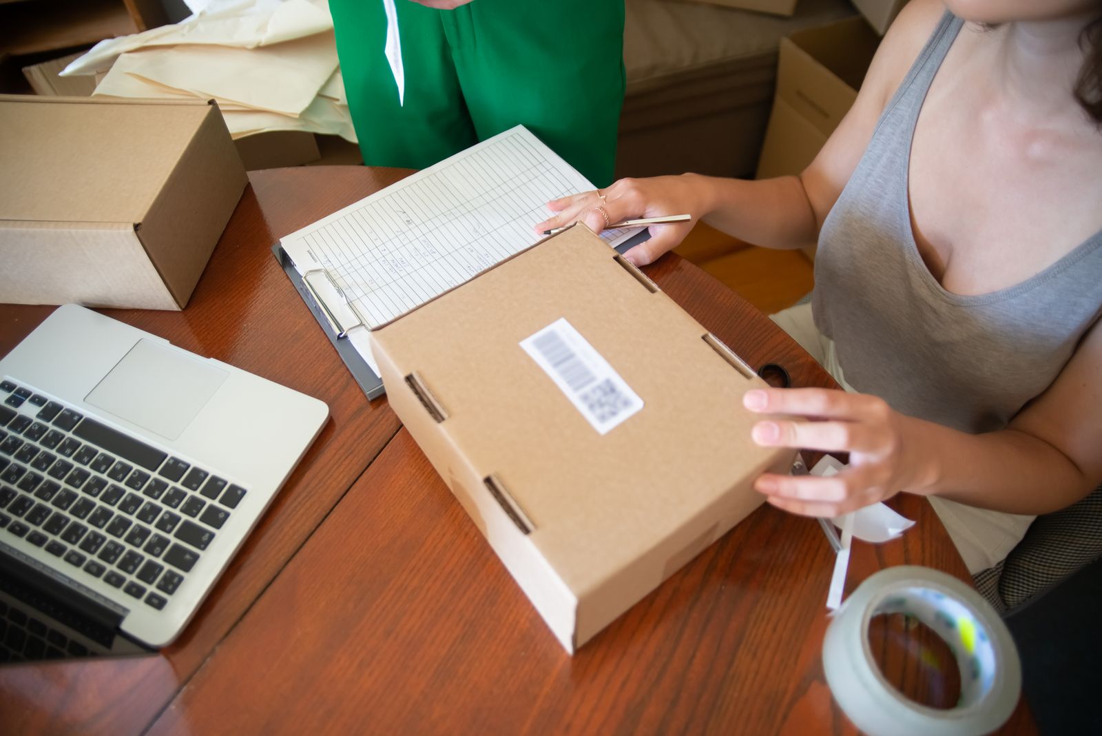 Online business owners packing orders beside a laptop